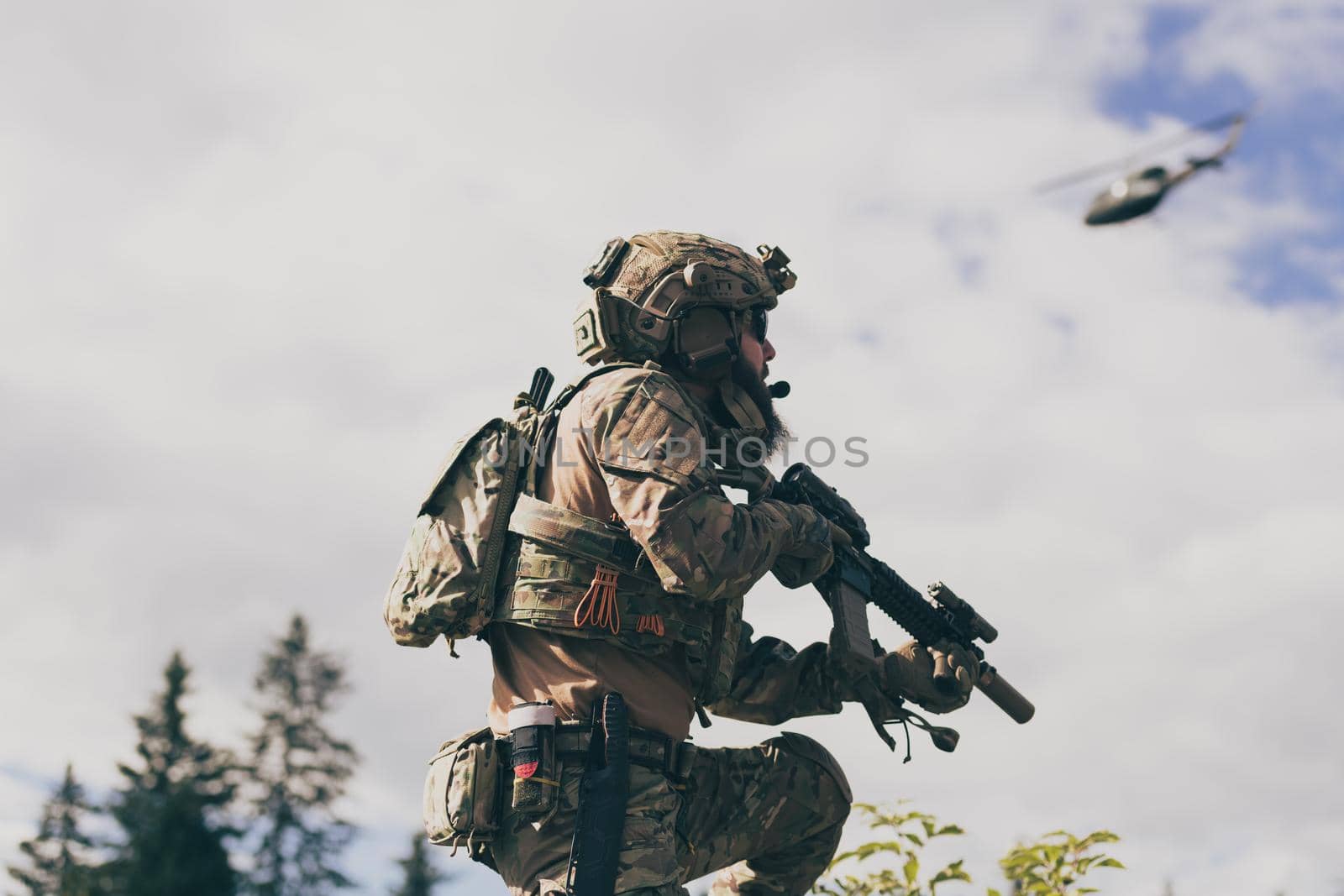 War concept. A bearded soldier in a special forces uniform fighting an enemy in a forest area. Selective focus. High-quality photo
