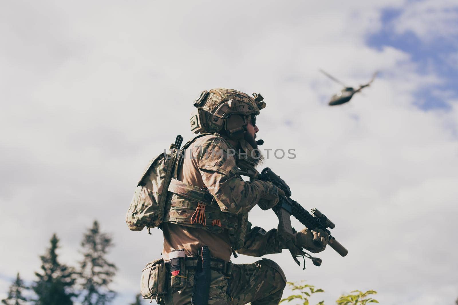 War concept. A bearded soldier in a special forces uniform fighting an enemy in a forest area. Selective focus by dotshock