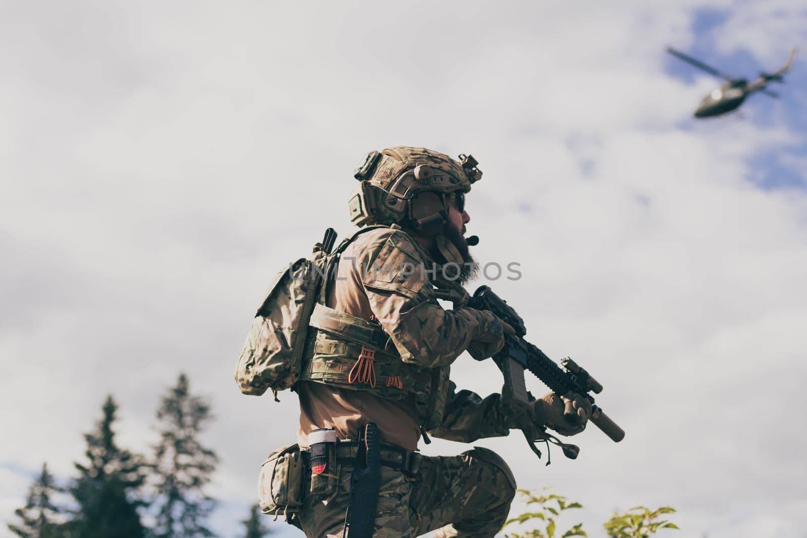 War concept. A bearded soldier in a special forces uniform fighting an enemy in a forest area. Selective focus by dotshock