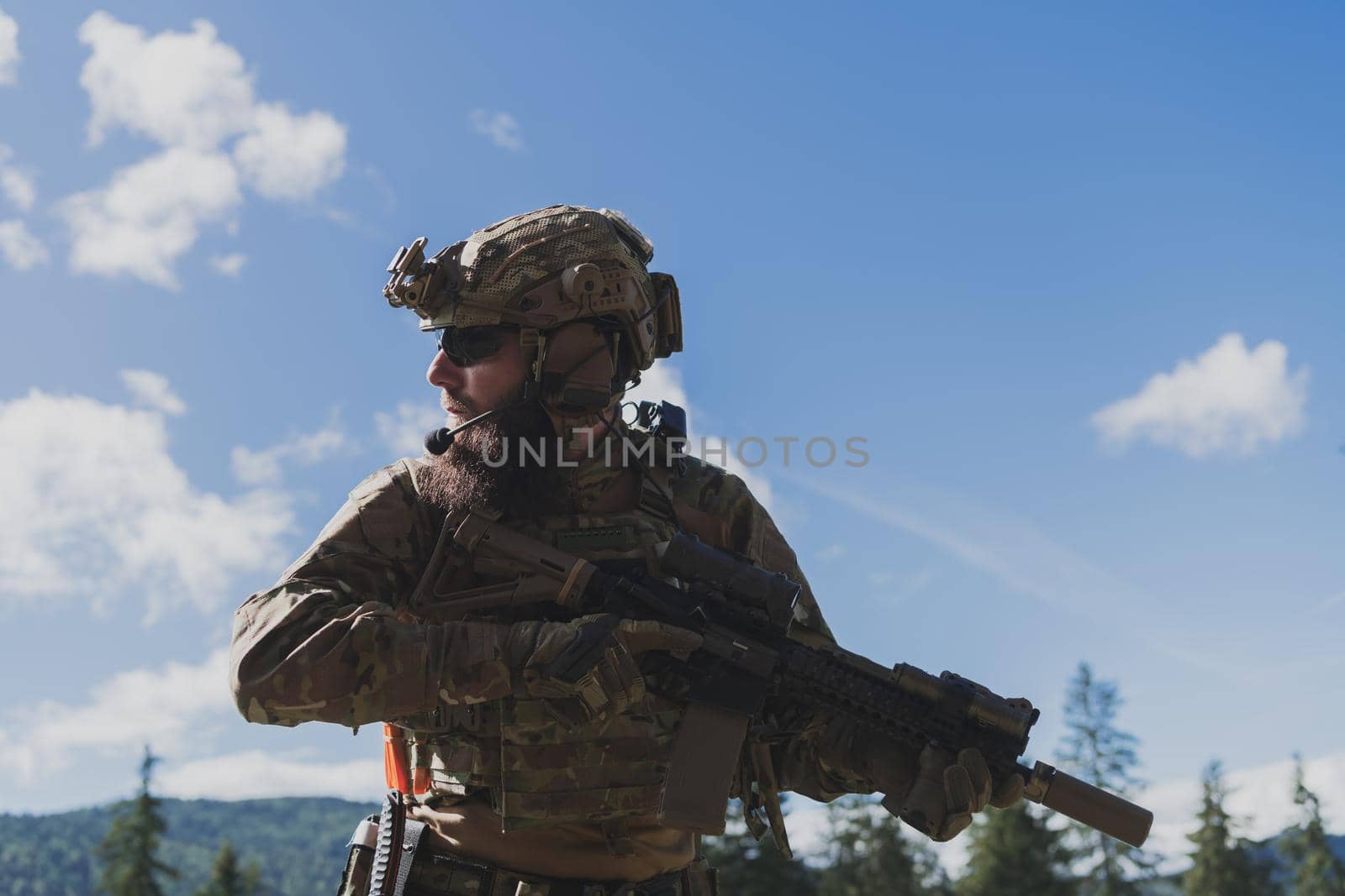 War concept. A bearded soldier in a special forces uniform fighting an enemy in a forest area. Selective focus by dotshock