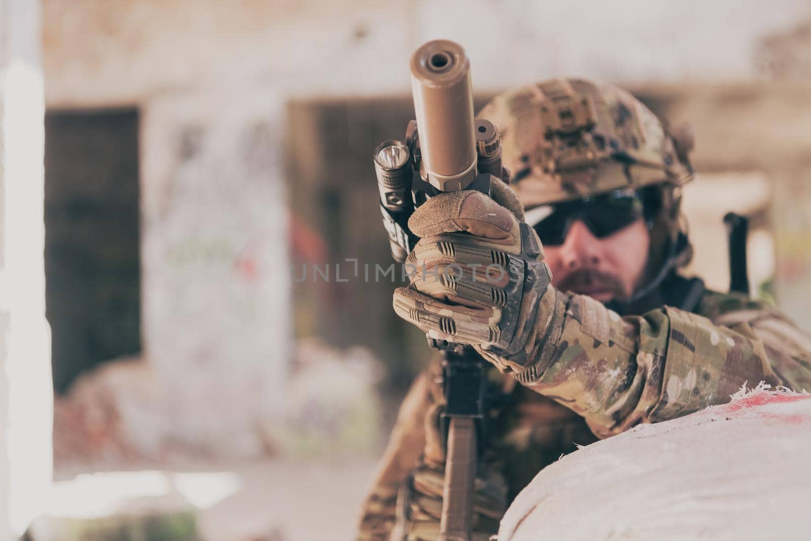 A bearded soldier in uniform of special forces in a dangerous military action in a dangerous enemy area. Selective focus by dotshock