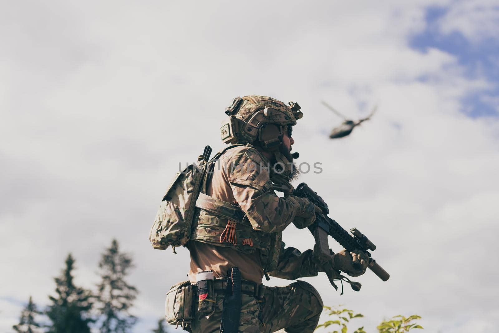 War concept. A bearded soldier in a special forces uniform fighting an enemy in a forest area. Selective focus by dotshock