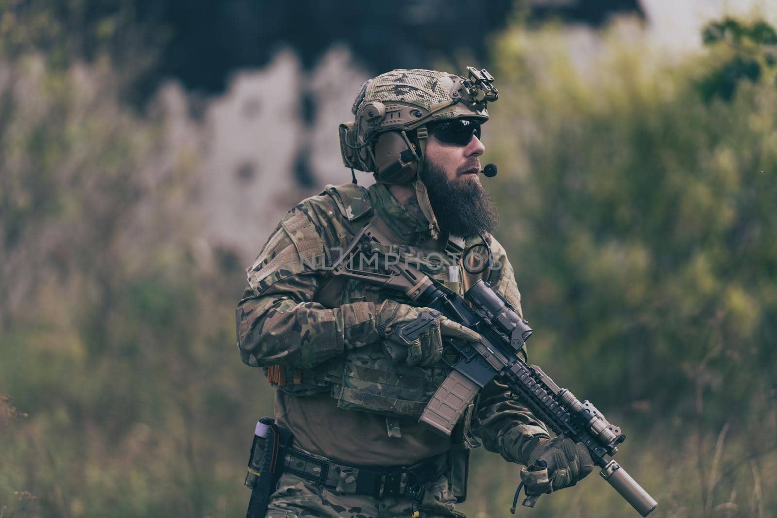 A bearded soldier in uniform of special forces in a dangerous military action in a dangerous enemy area. Selective focus by dotshock