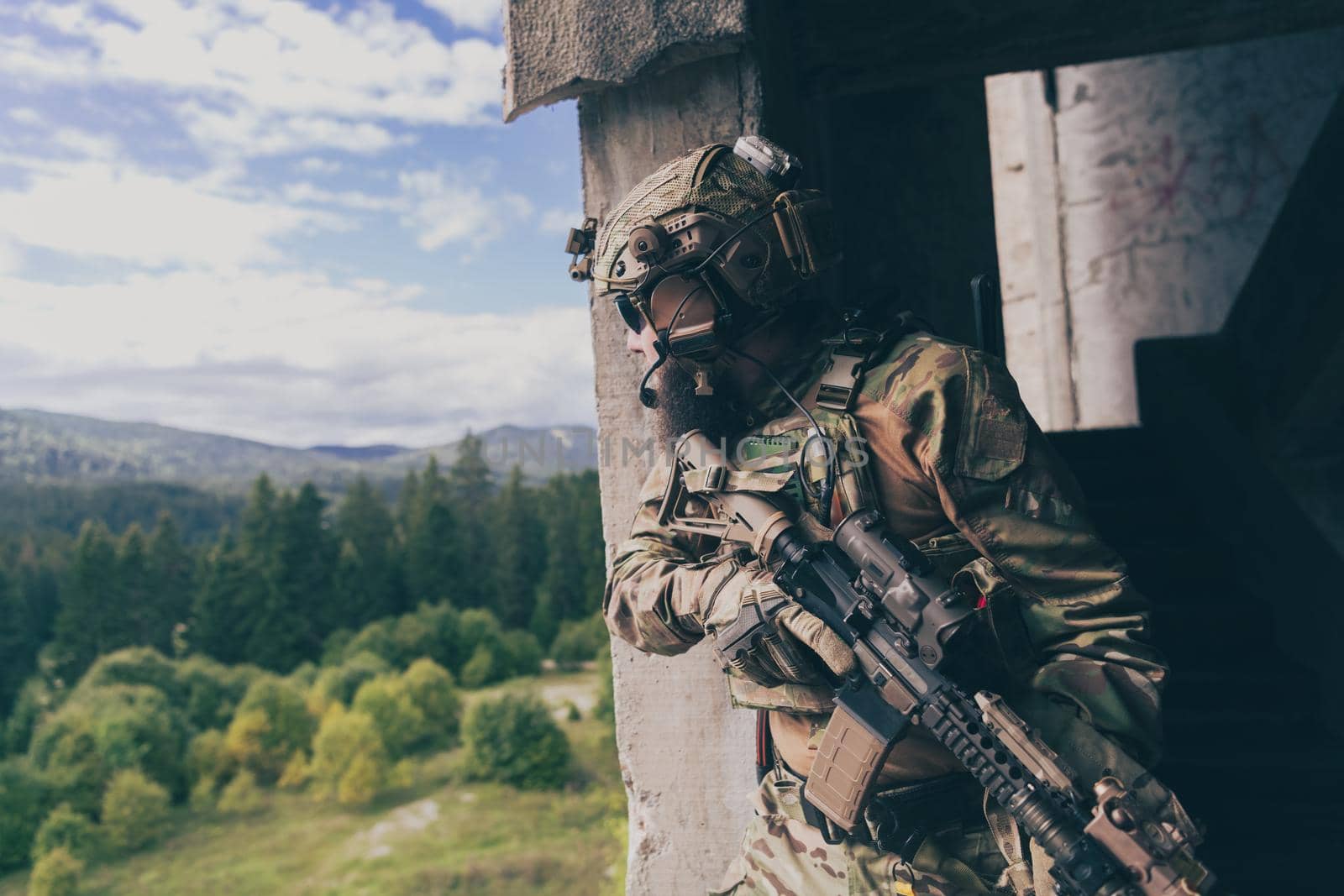 A bearded soldier in uniform of special forces in a dangerous military action in a dangerous enemy area. Selective focus by dotshock