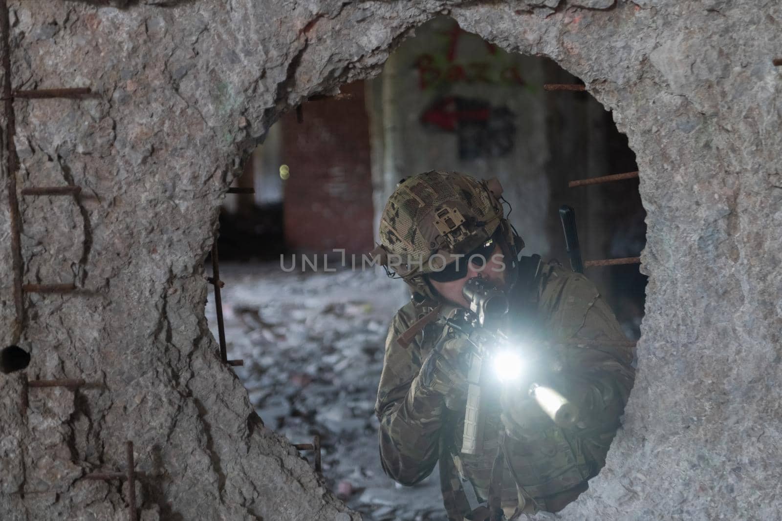 A bearded soldier in uniform of special forces in a dangerous military action in a dangerous enemy area. Selective focus by dotshock