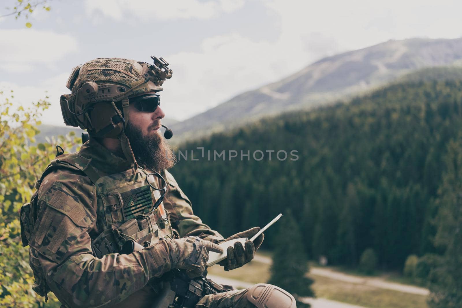 War concept. Bearded soldier in uniform of special forces in dangerous military action in dangerous enemy area studies attack tactics. Selective focus. High-quality photo