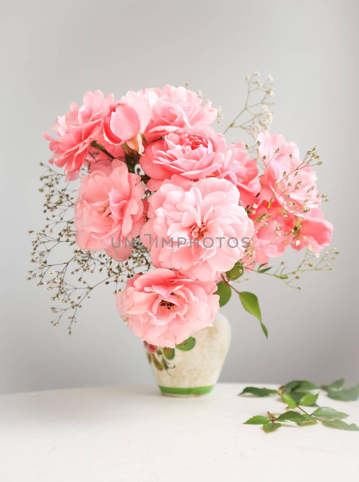 Bouquet of pink roses in a vase on a gray background