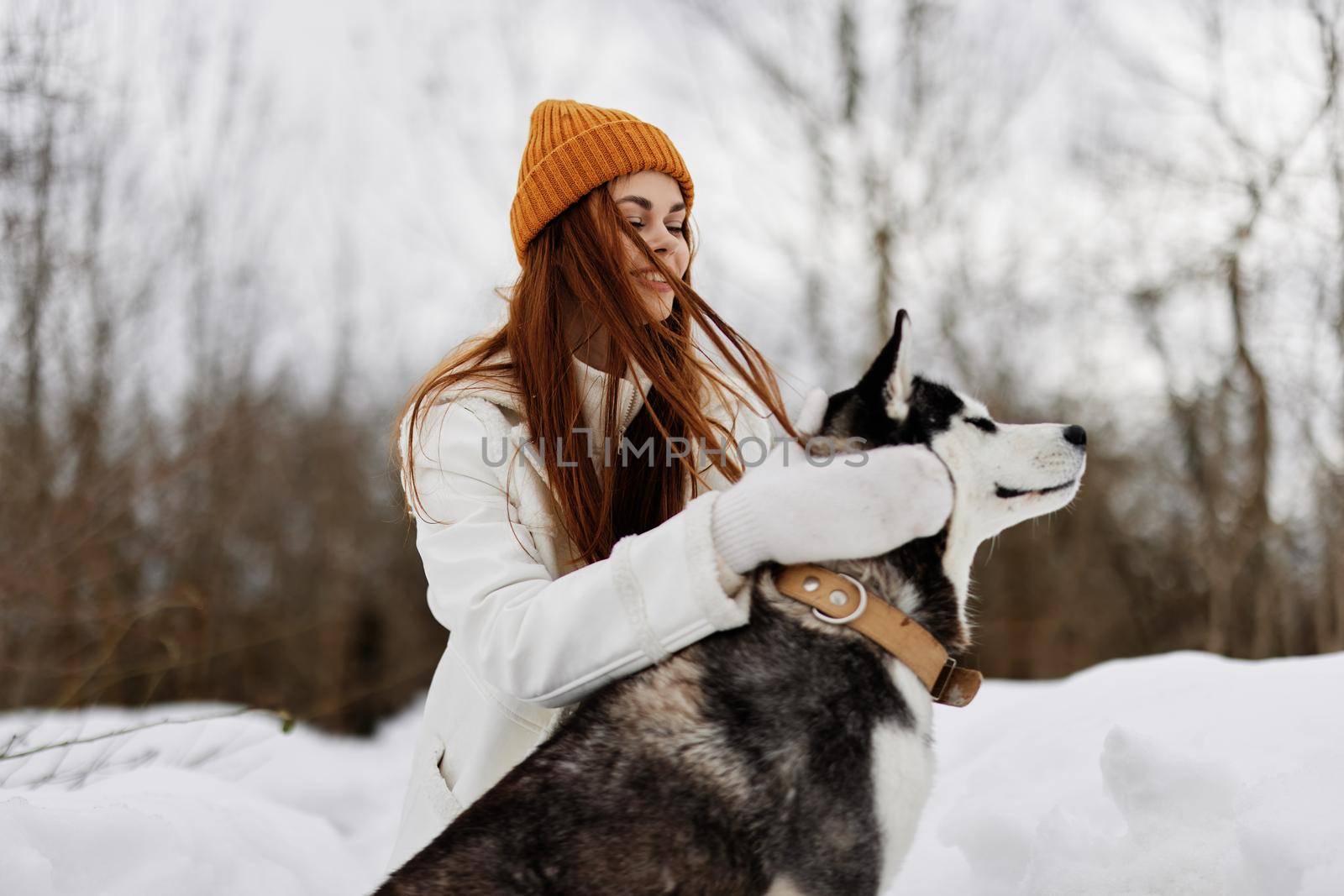 cheerful woman winter clothes walking the dog in the snow winter holidays. High quality photo