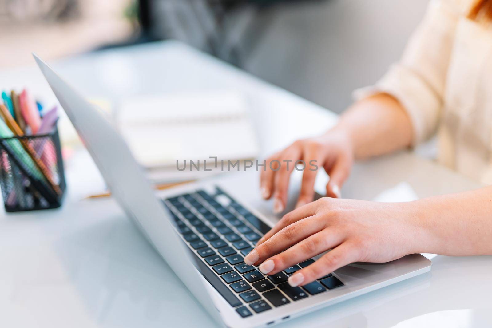 Young girl typing on laptop at home by CatPhotography