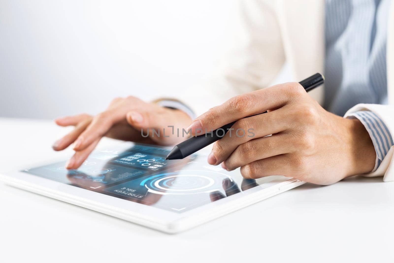 Man in white business suit using tablet computer. Close-up of male hands holding pen and tablet gadget. Mobile smart device in business occupation. Online services of business analytics for trading