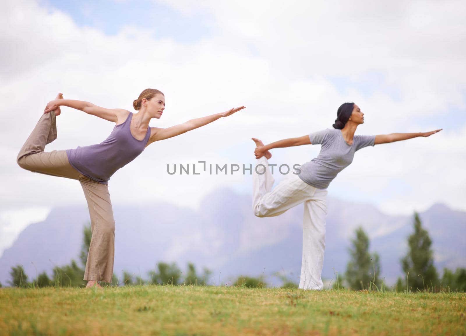Women doing yoga outdoors.