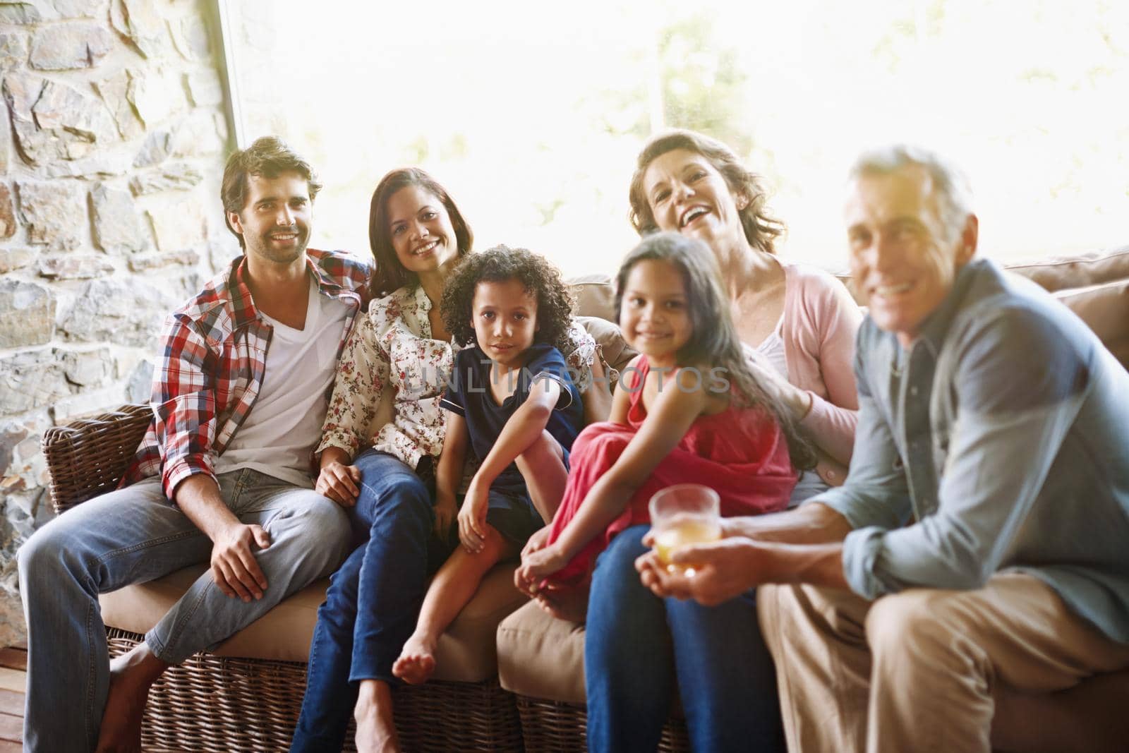 Three generations of laughter and love. A portrait of a three generation family relaxing together at home. by YuriArcurs