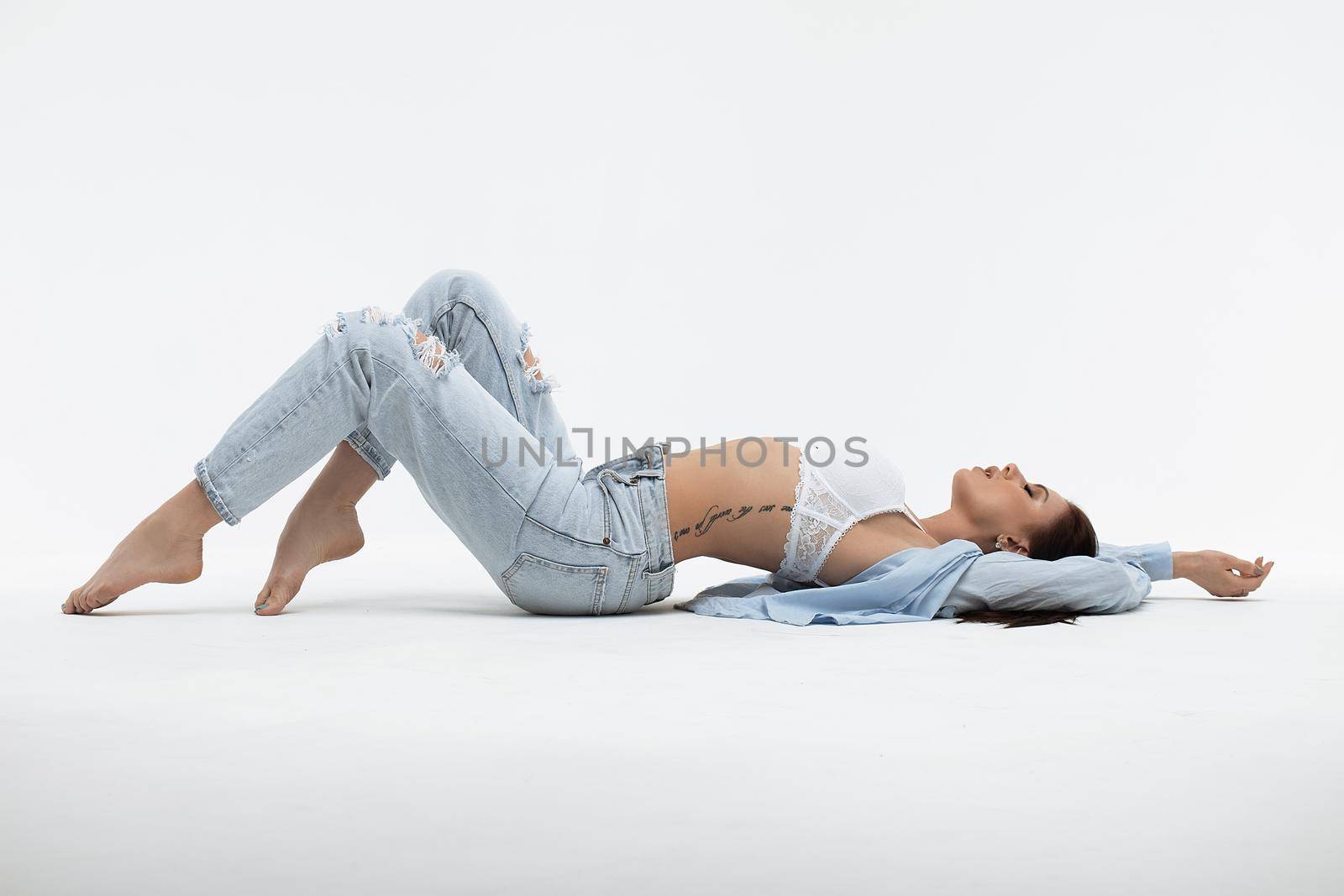 Sensual woman in brassiere and casual apparel on light background by 3KStudio