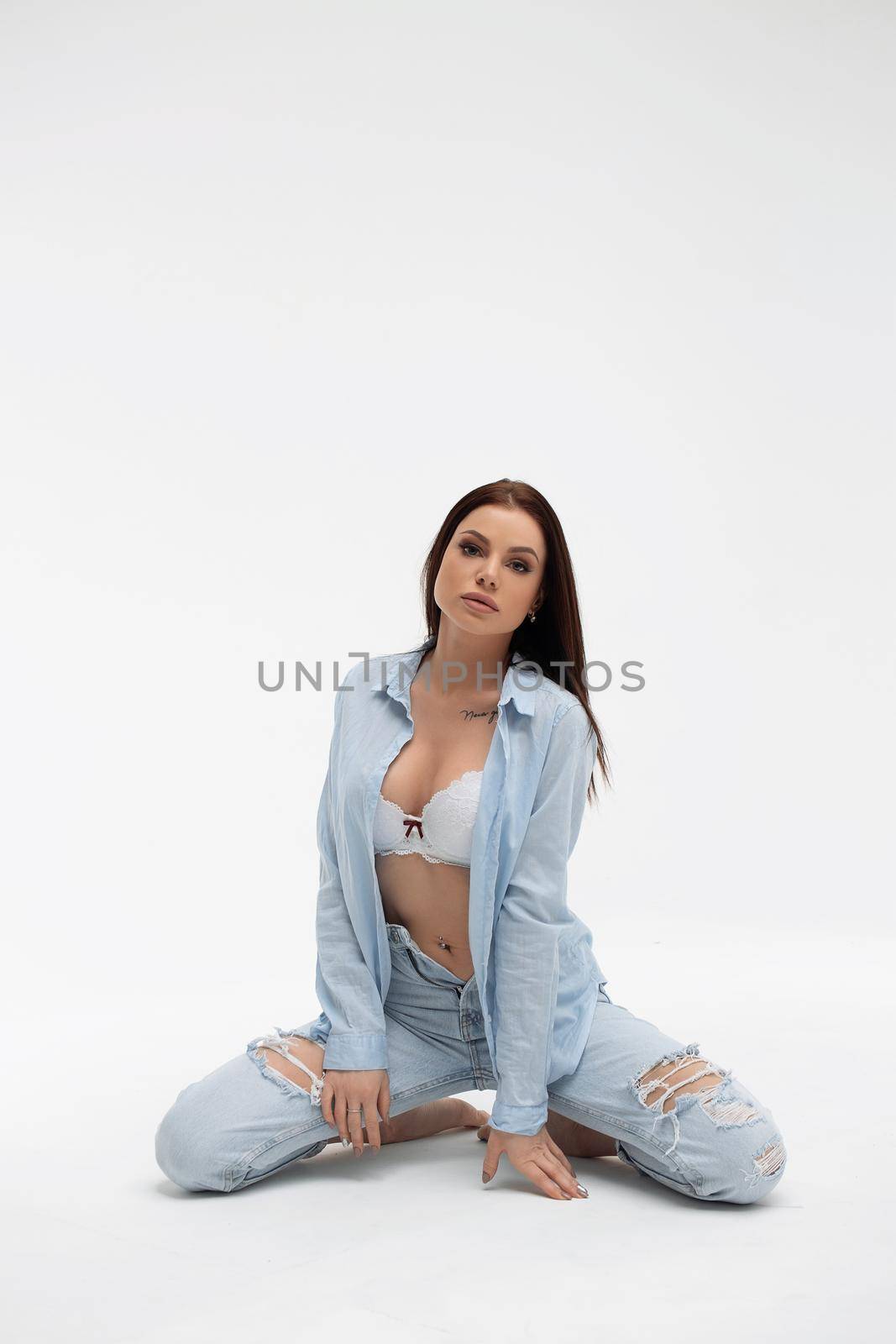 Sensual woman in brassiere and casual apparel on light background by 3KStudio