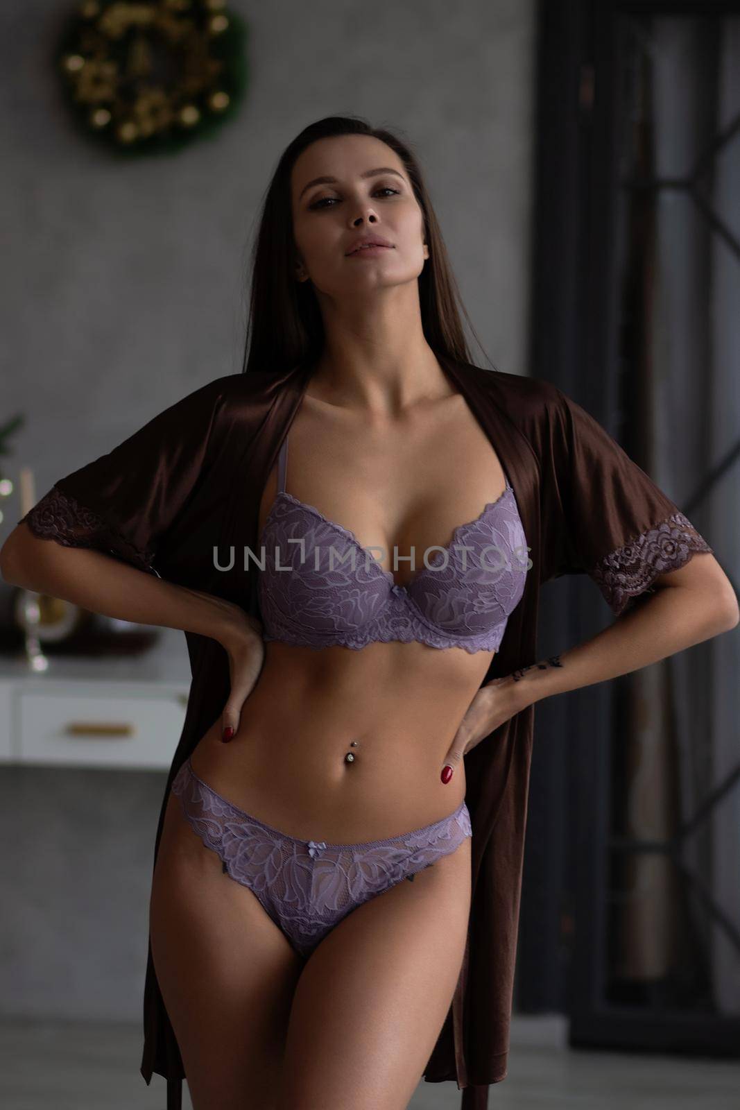 Gorgeous young female model wearing various stylish underwear during Christmas holidays at home by 3KStudio