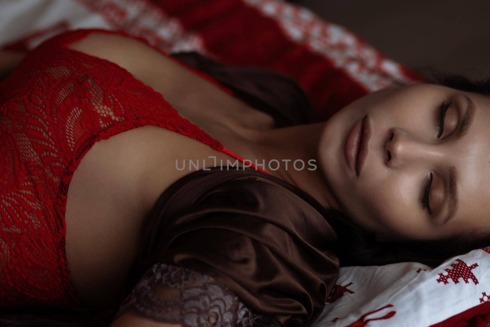 Alluring young lady relaxing on bed with closed eyes during Christmas holidays by 3KStudio