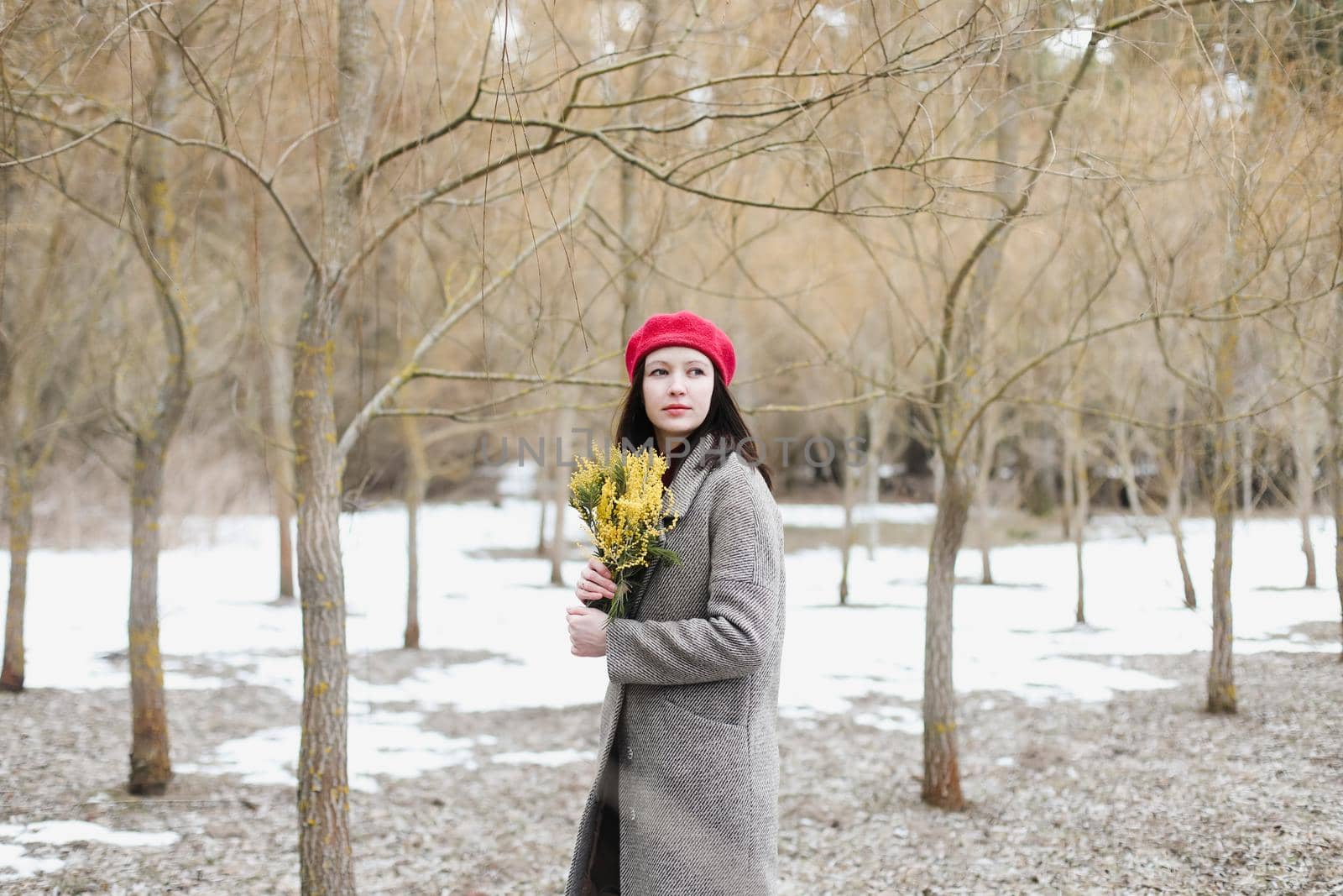 beautiful portrait of a young woman with mimosa flowers outdoors