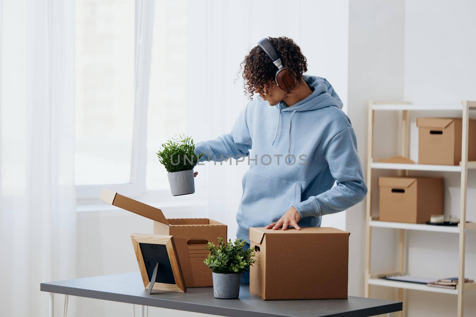 A young man unpacking things from boxes in the room Lifestyle. High quality photo