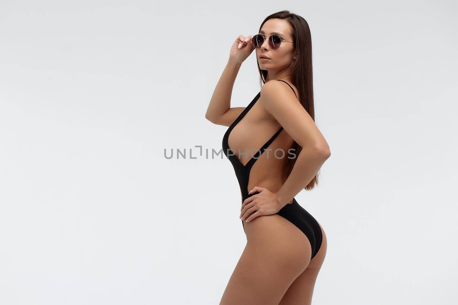 Stylish model in sexy swimsuit and sunglasses by 3KStudio