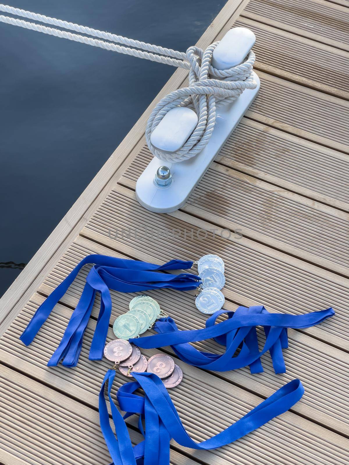 The sea rope on the knecht in new port, a lot of medals of the winners of the yacht regatta lie on the edge of the pier. High quality photo