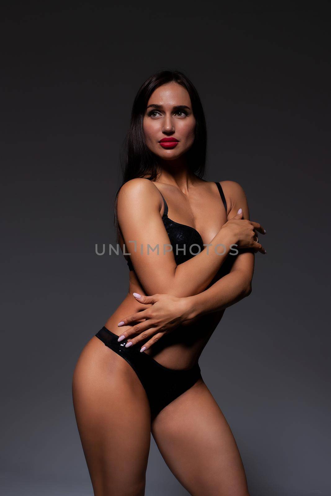 Voluptuous woman in underwear standing gracefully in studio by 3KStudio