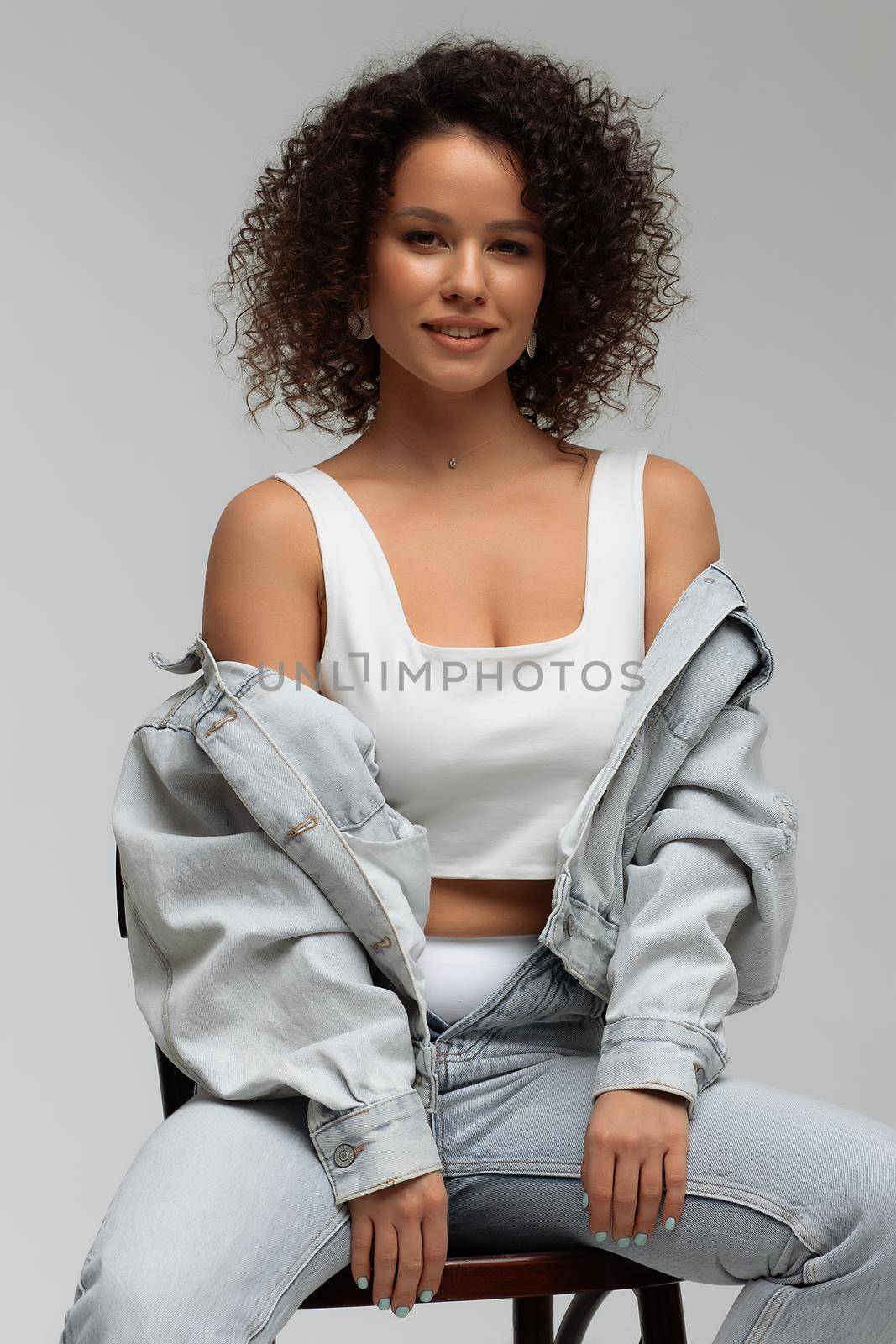 Stylish curly haired woman in denim outfit by 3KStudio