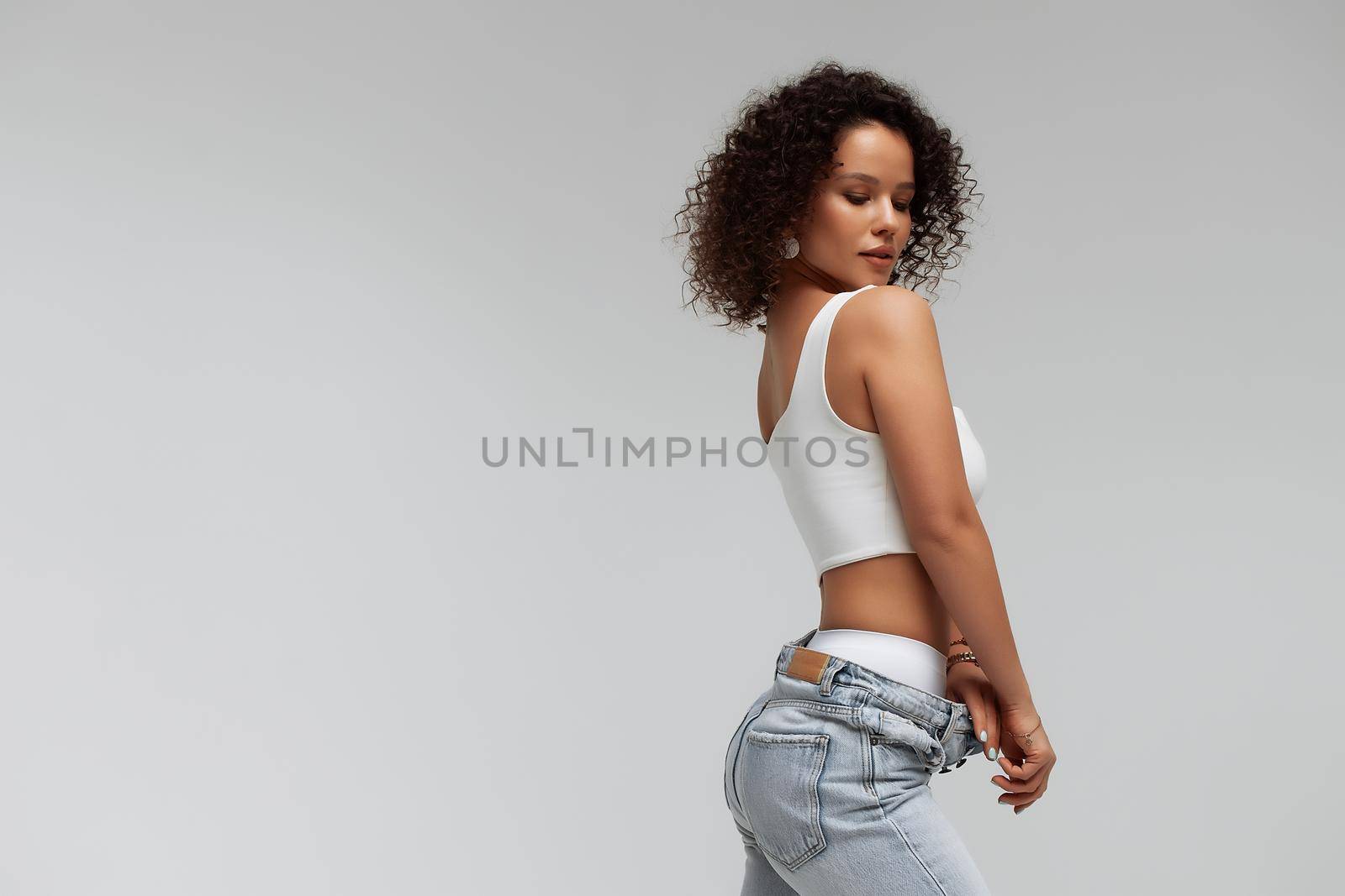 Stylish curly haired woman in denim outfit by 3KStudio