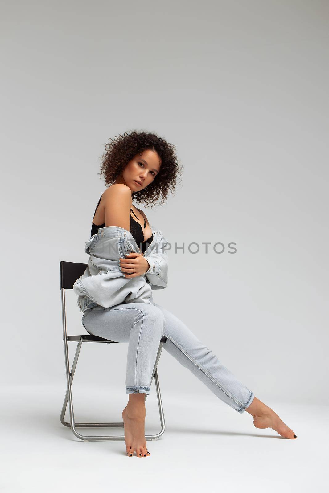 Stylish curly haired woman in denim outfit by 3KStudio