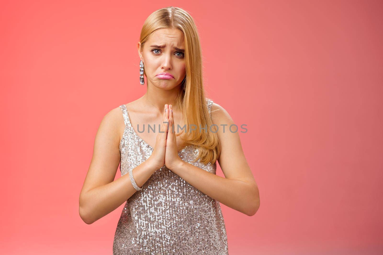Pity charming young cute upset blond girlfriend begging favour lend lipstick dress-up party silver stylish glittering dress frowning press palms together pray asking forgiveness, favour.