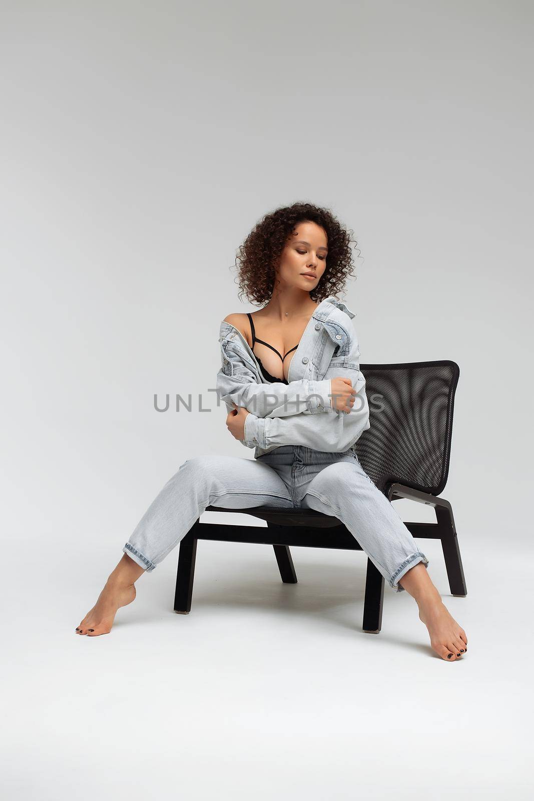 Stylish curly haired woman in denim outfit by 3KStudio