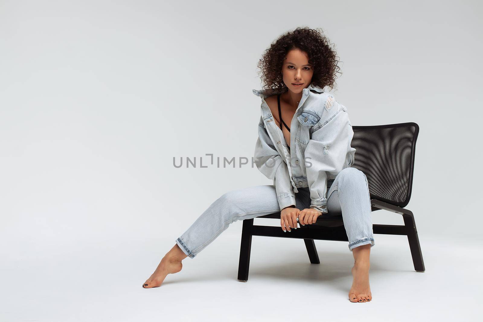 Stylish curly haired woman in denim outfit by 3KStudio