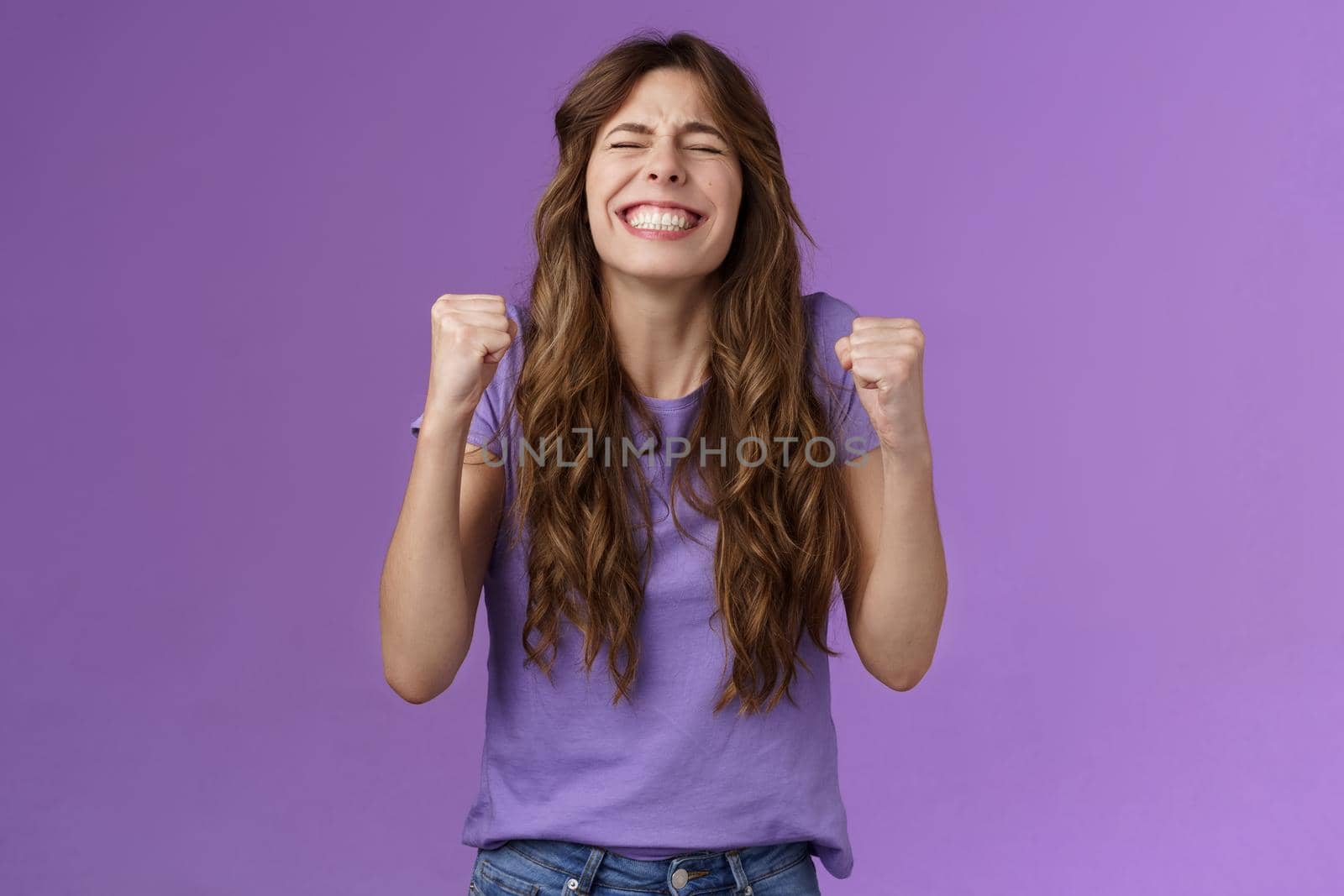 Yes I did it. Relieved happy triumphing joyful girl pump fists celebrating excellent achievement raise head up close eyes thank god winning first prize stand purple background happy.