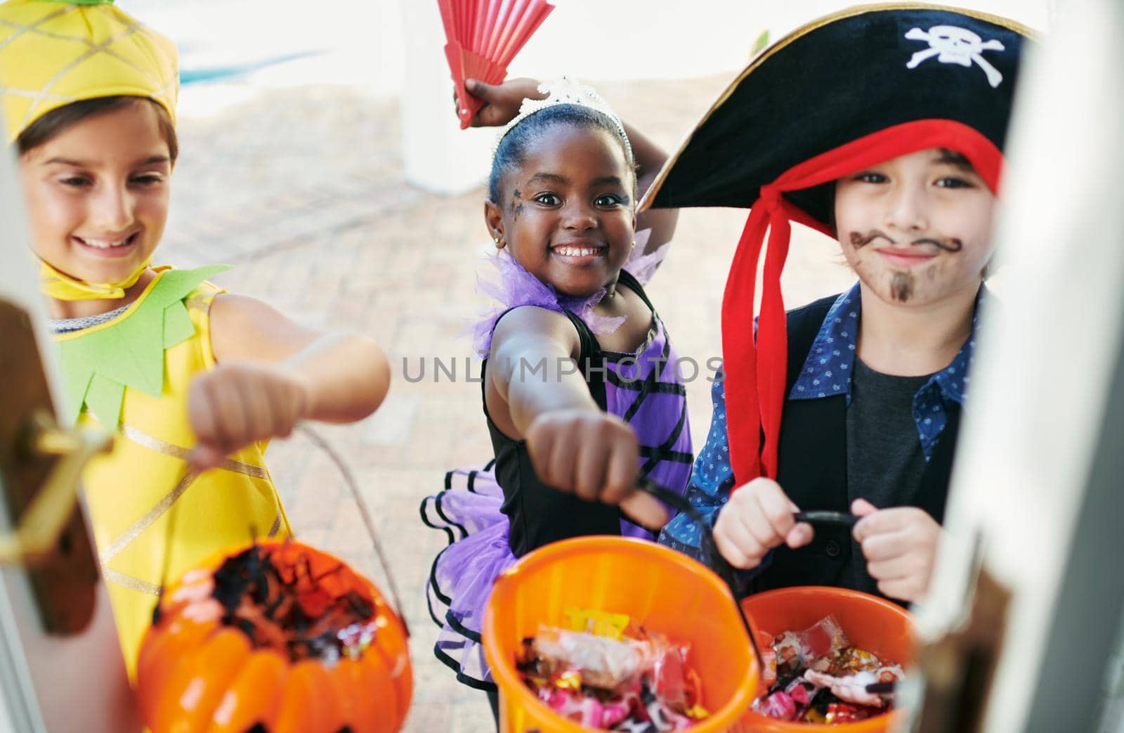 Candy time. Shot of a group of little children going trick-or-treating. by YuriArcurs