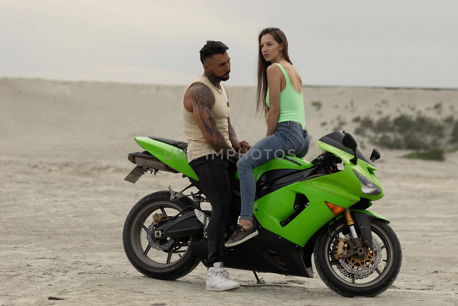 Stylish couple on motorbike on beach by 3KStudio
