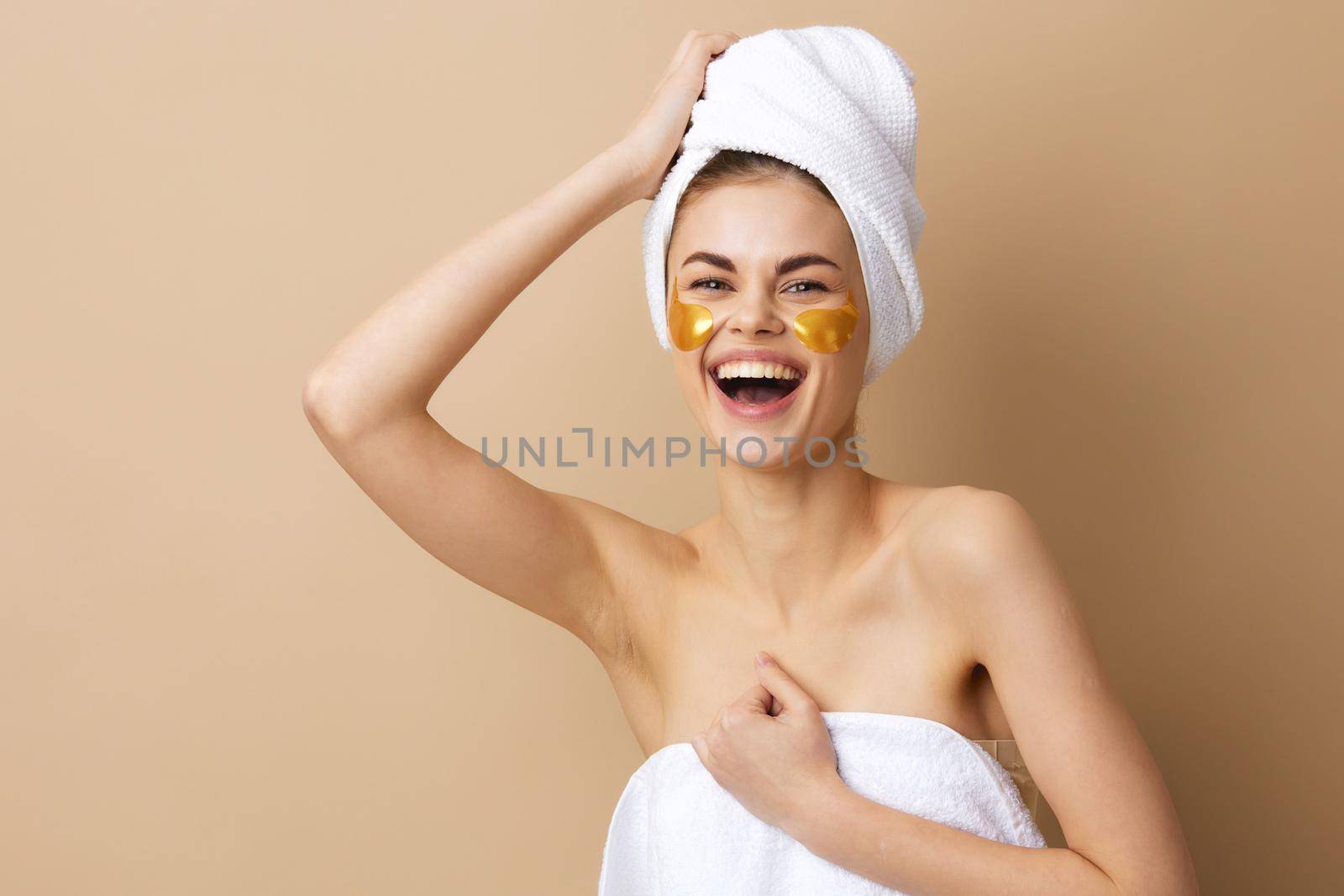 young woman golden patches on the face with a towel on the head close-up Lifestyle. High quality photo