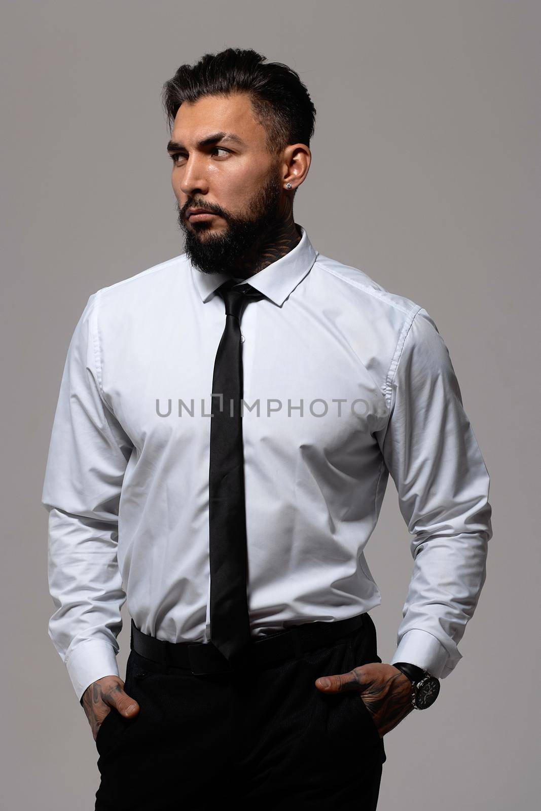 Man in elegant clothes on gray backdrop by 3KStudio