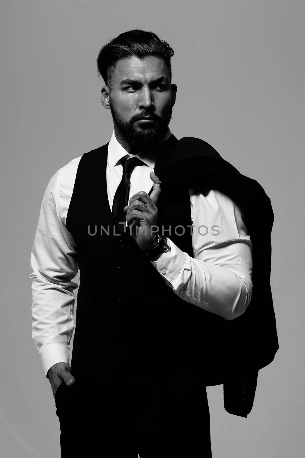 Man in elegant clothes on gray backdrop by 3KStudio