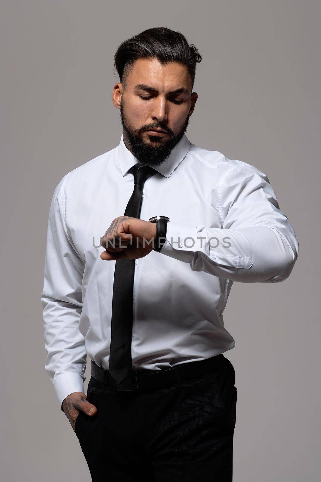 Man in elegant clothes on gray backdrop by 3KStudio