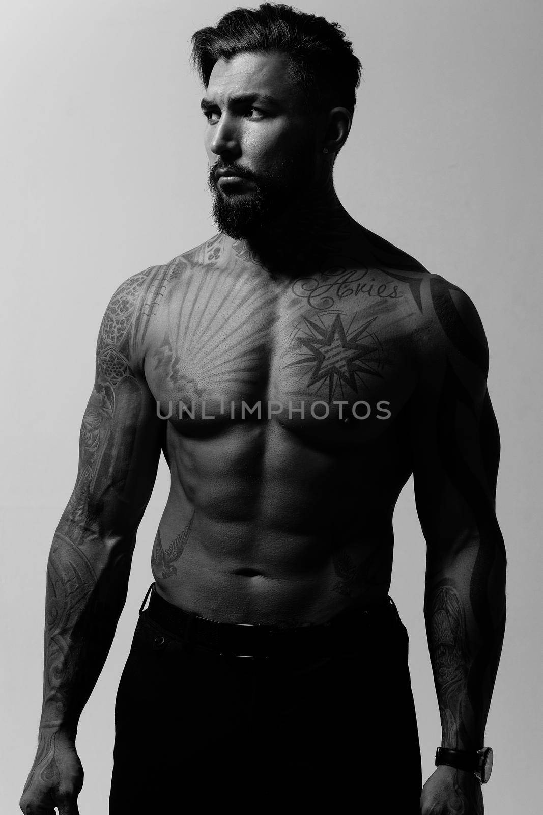 Muscular shirtless tattooed guy in studio by 3KStudio