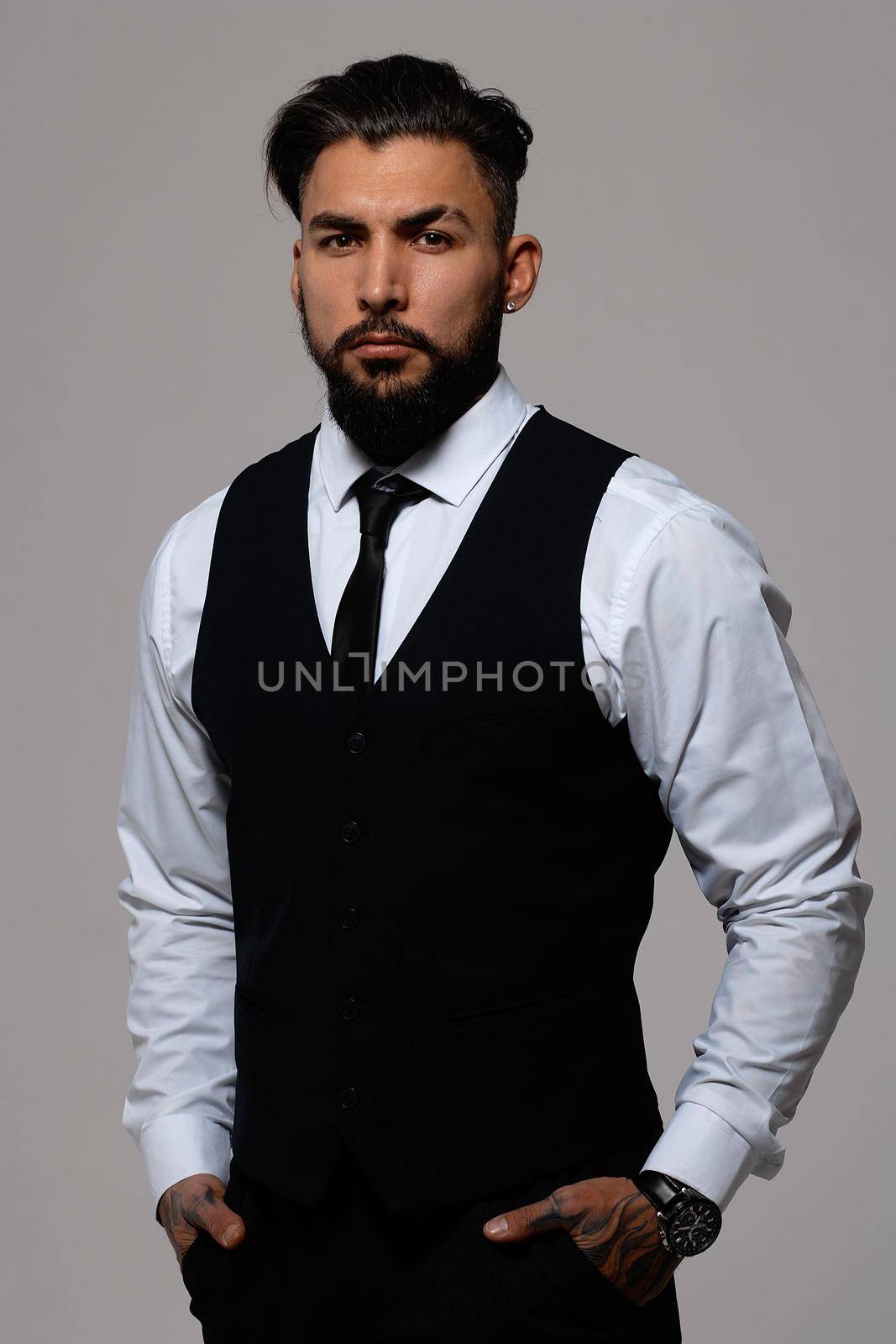 Man in elegant clothes on gray backdrop by 3KStudio