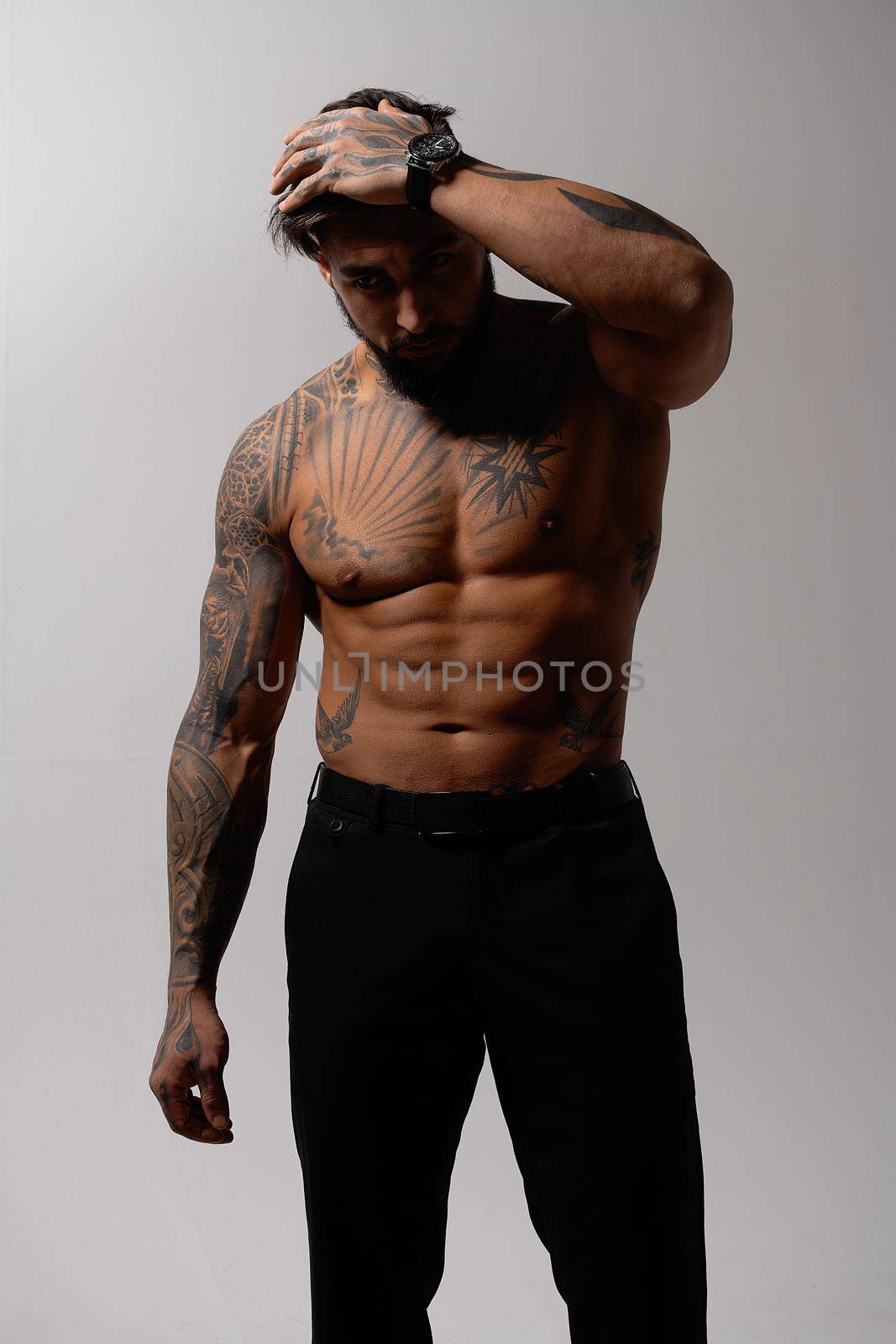 Muscular shirtless tattooed guy in studio by 3KStudio