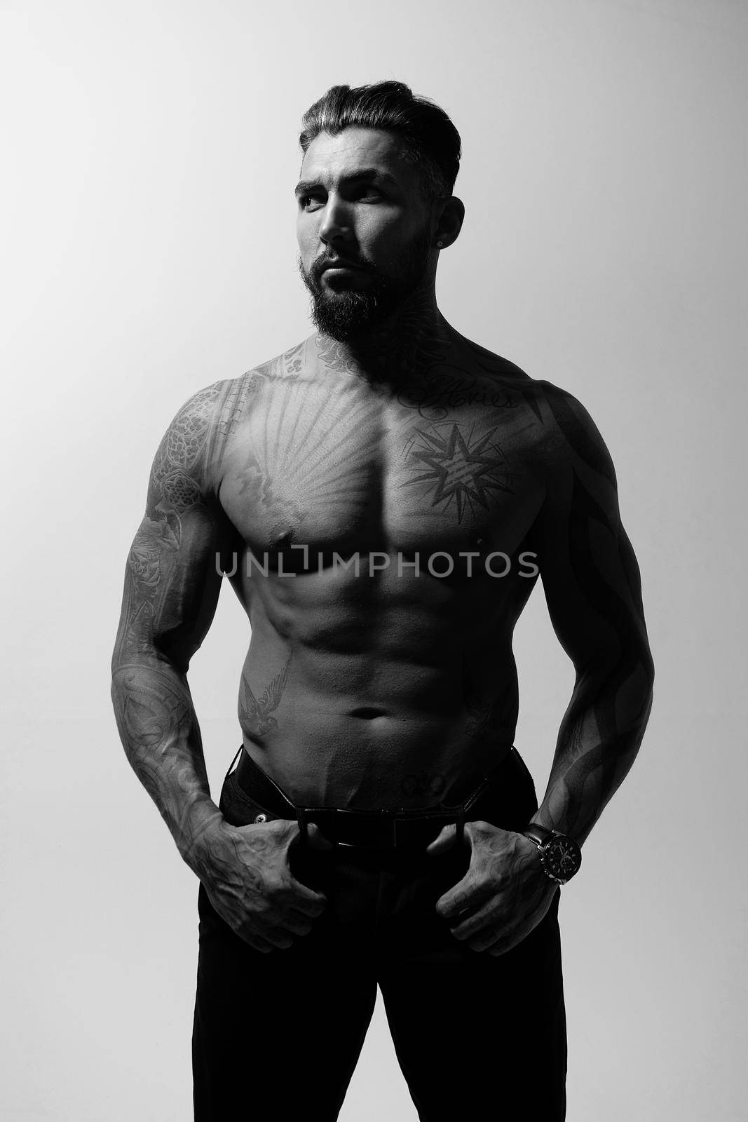 Muscular shirtless tattooed guy in studio by 3KStudio