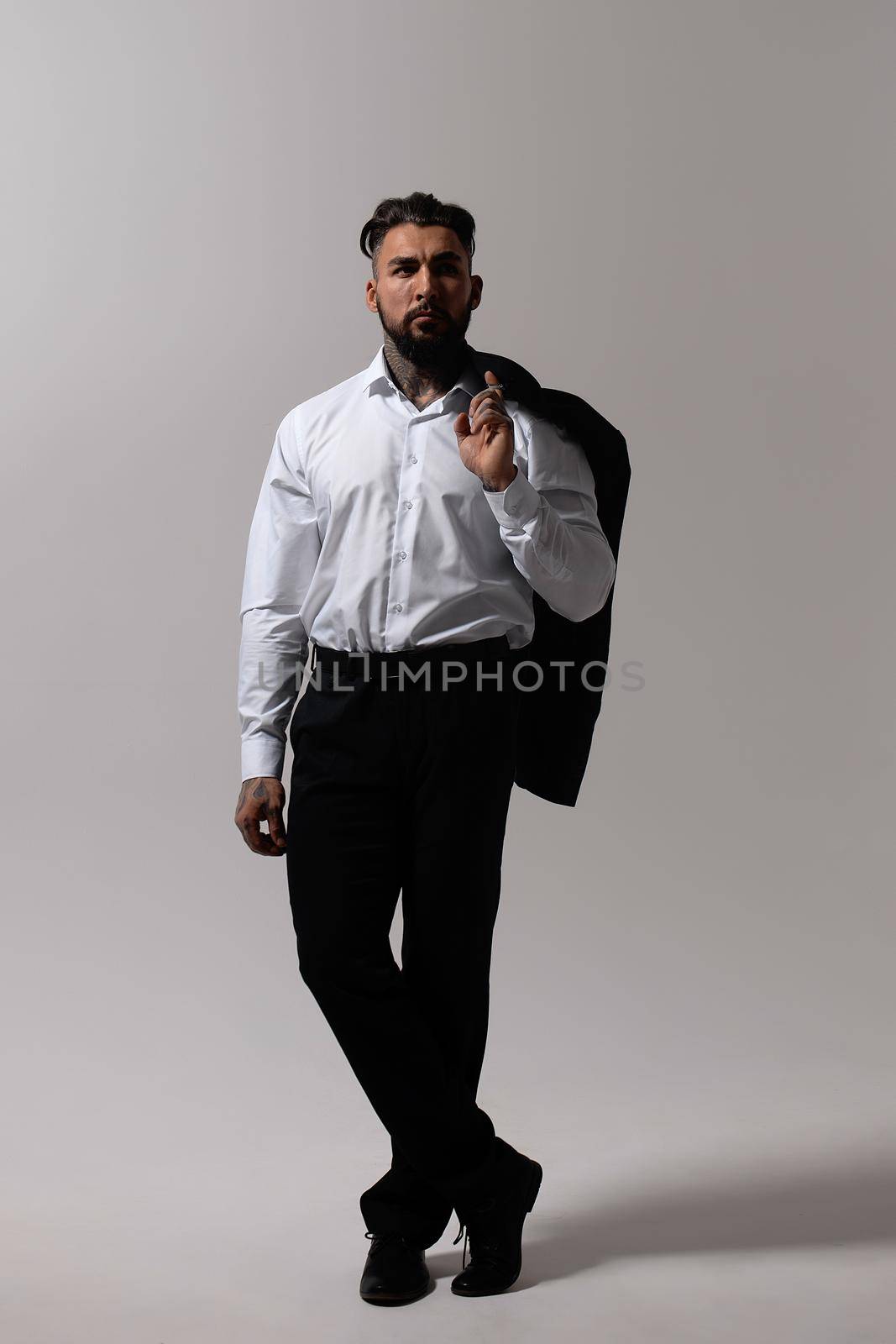 Man in elegant clothes on gray backdrop by 3KStudio