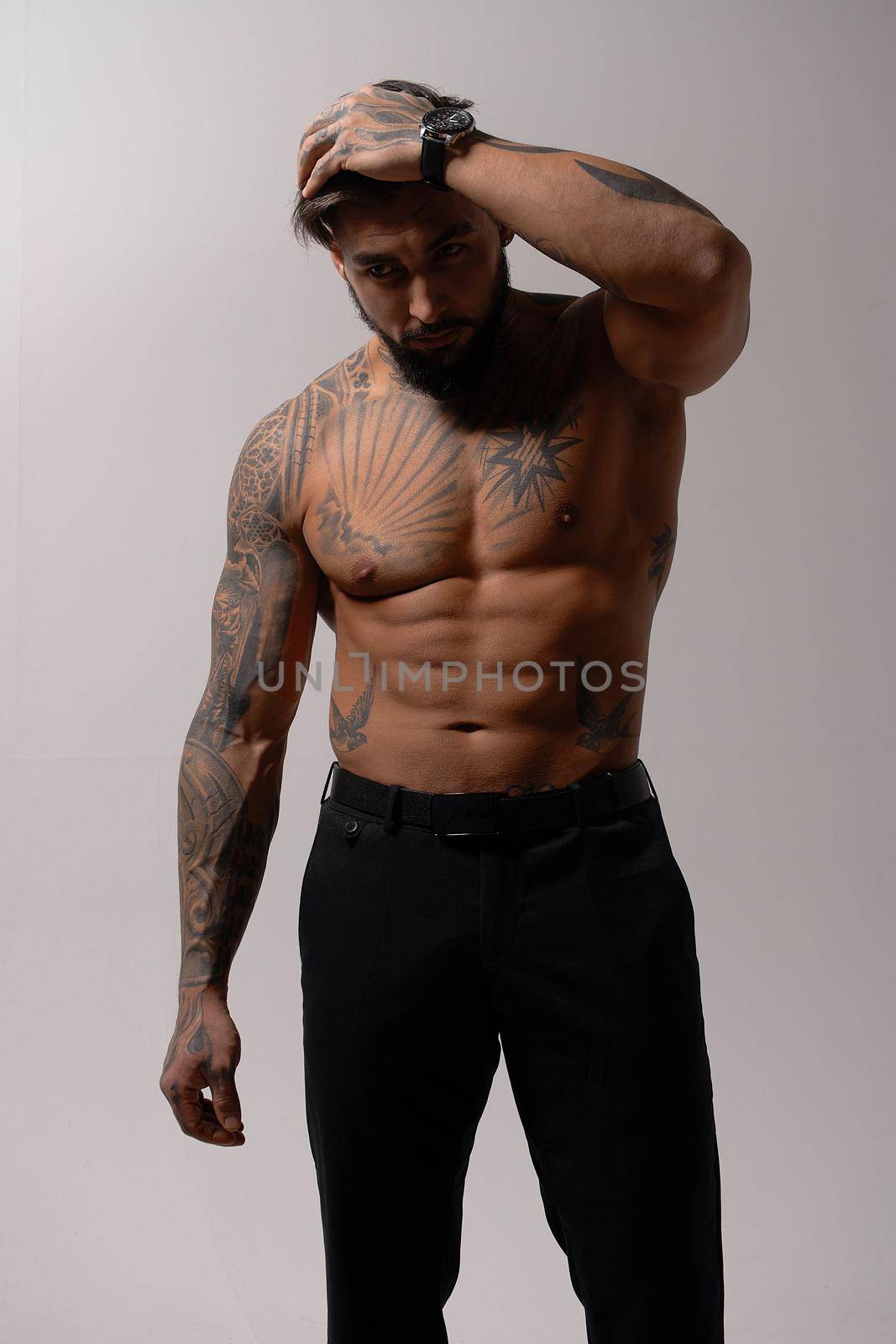 Muscular shirtless tattooed guy in studio by 3KStudio