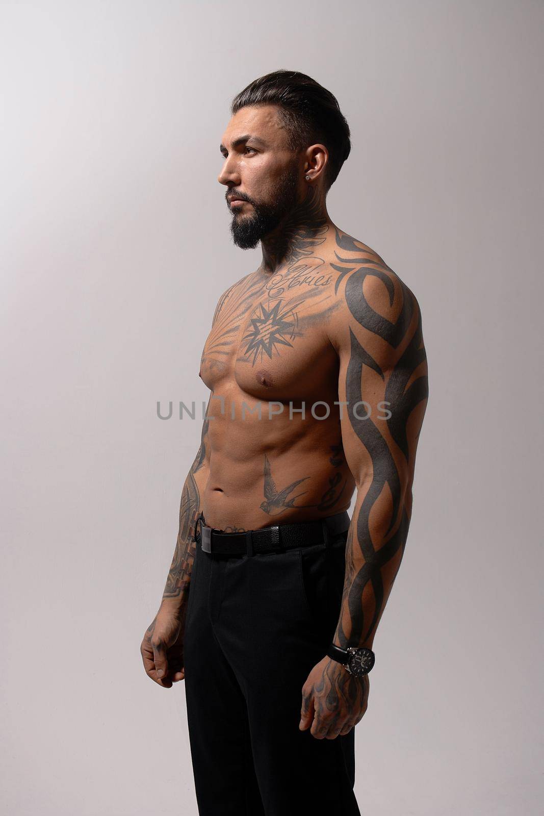 Muscular shirtless tattooed guy in studio by 3KStudio