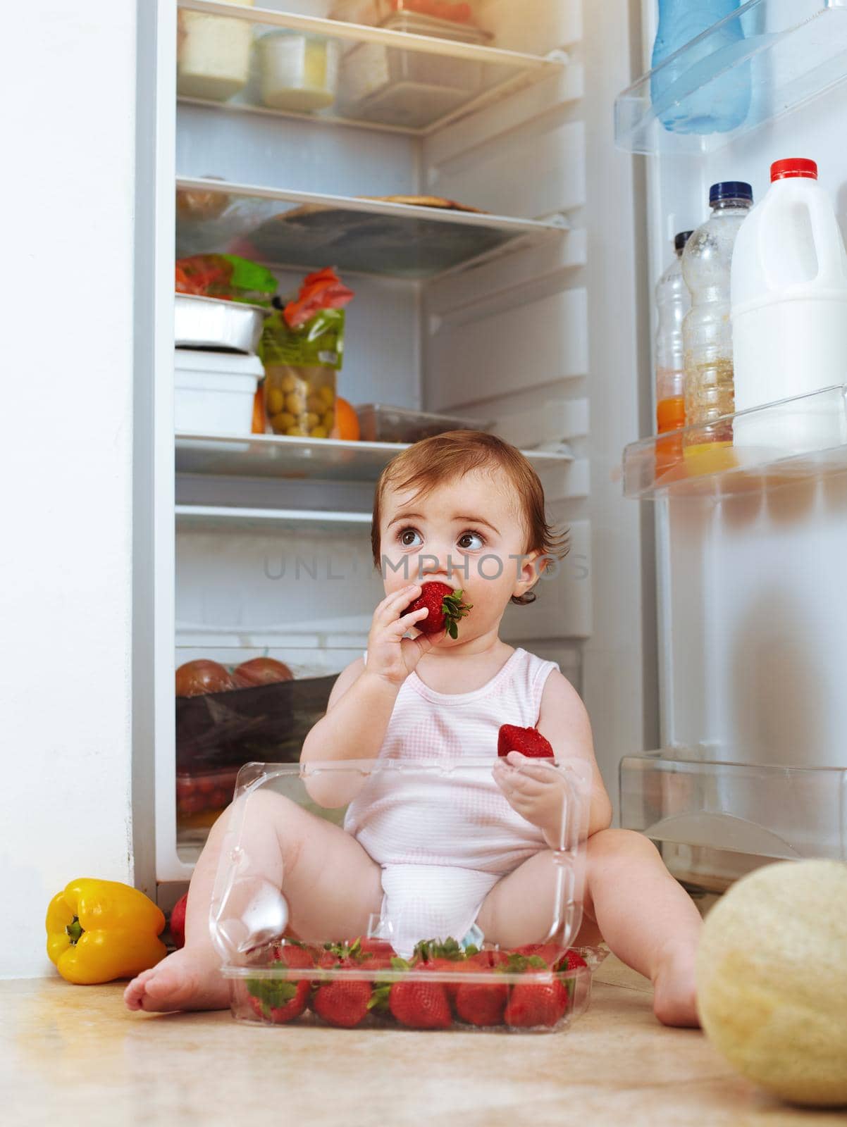 Shot of a toddler eating food from the fridge.