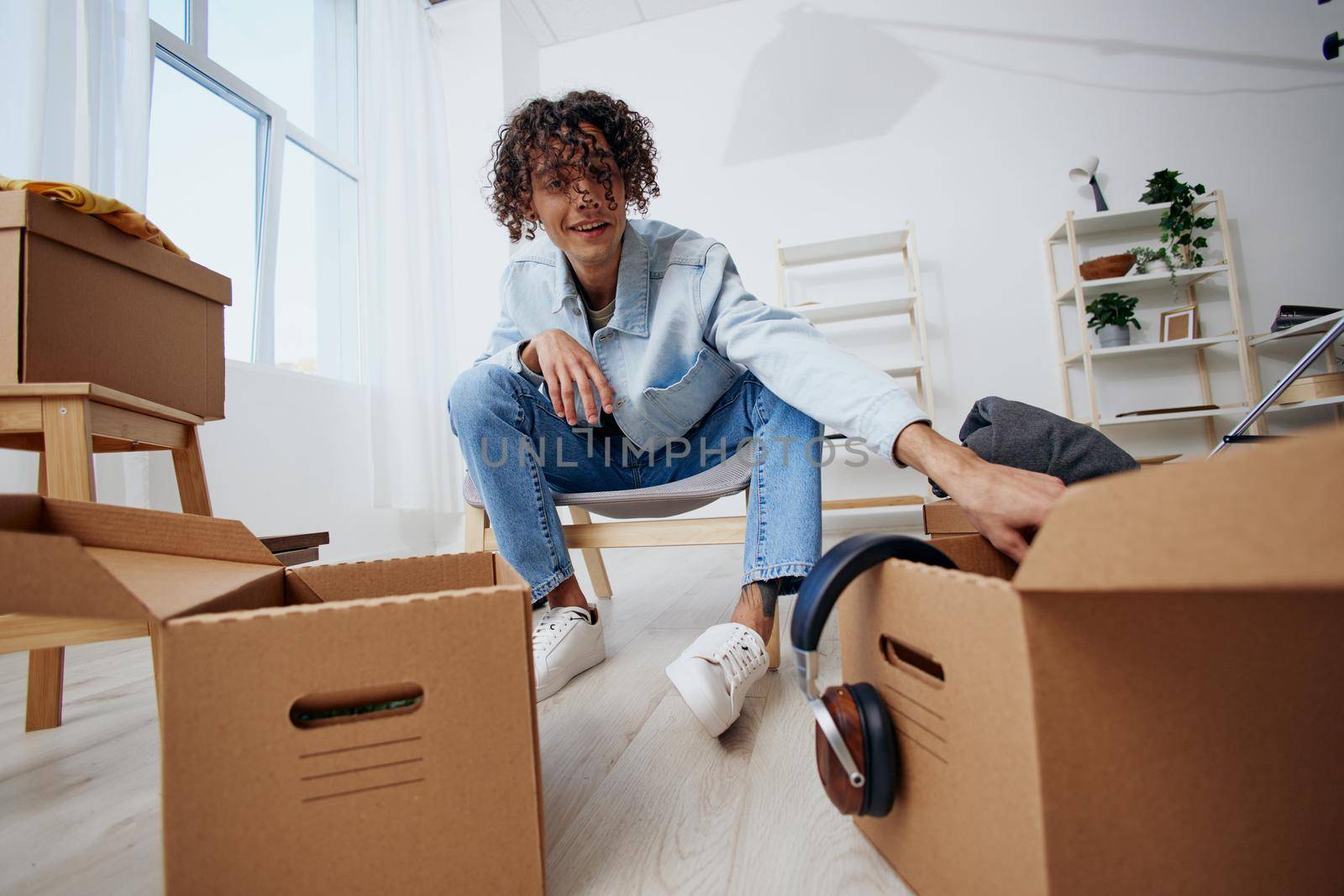 handsome guy unpacking things from boxes in the room sorting things out. High quality photo