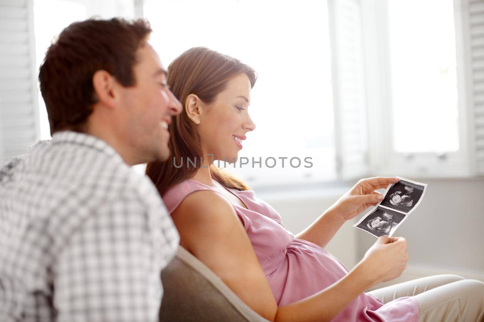 Happy young couple looking at a image of their babies sonogram.