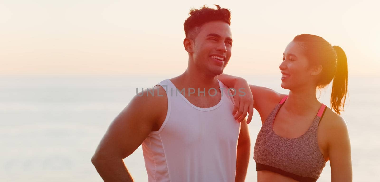 Cropped shot of an affectionate young couple looking happy while working out outdoors.