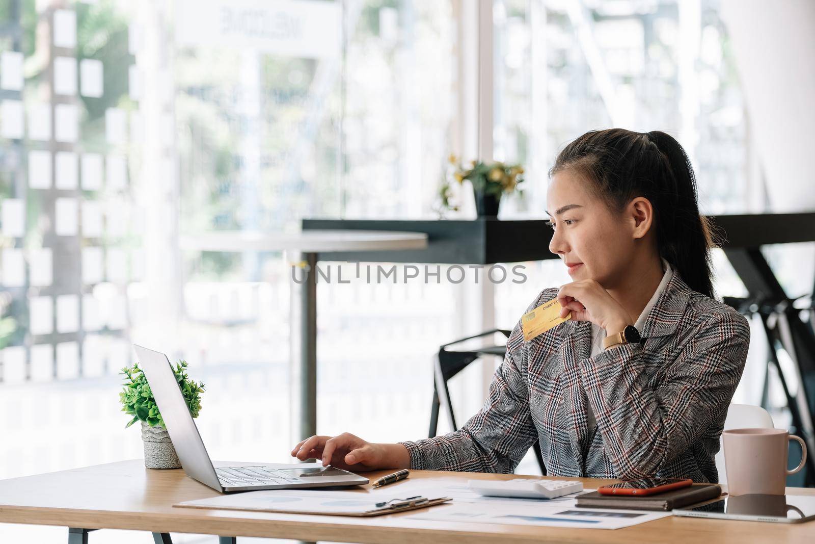 Happy asian woman hands holding credit card and using laptop computer. Online shopping concept